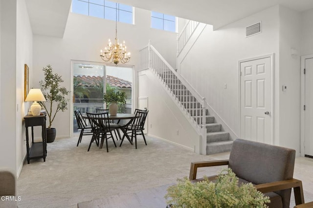 dining room featuring light carpet, visible vents, stairway, an inviting chandelier, and a high ceiling