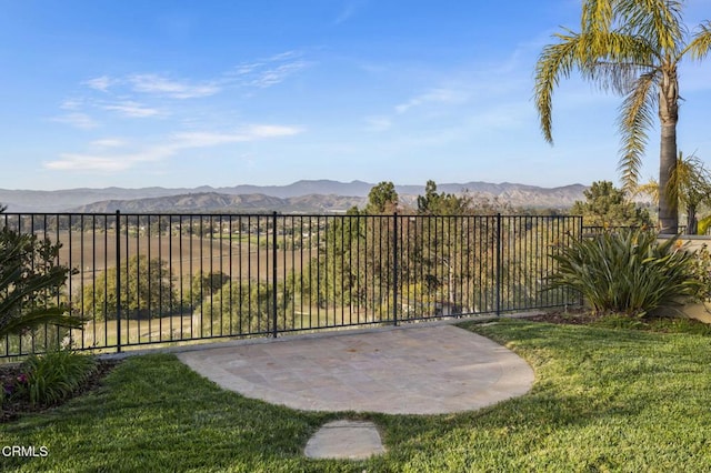 view of yard featuring a patio area, fence, and a mountain view