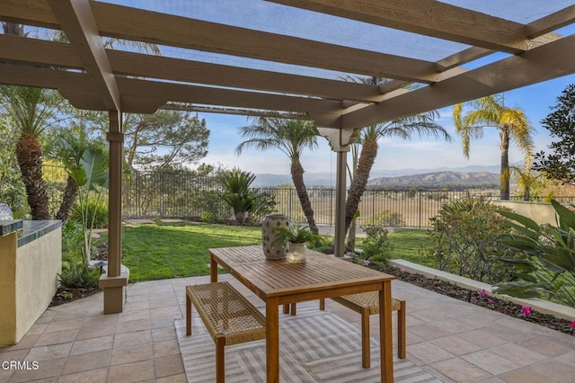 view of patio featuring a fenced backyard, a mountain view, and a pergola