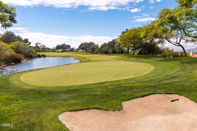 view of property's community featuring view of golf course, a lawn, and a water view