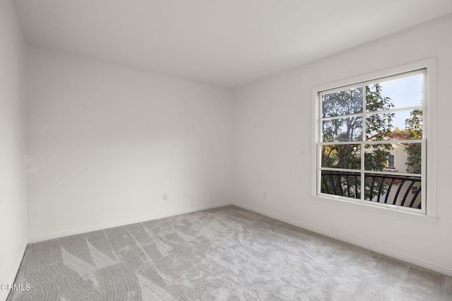 carpeted empty room featuring baseboards