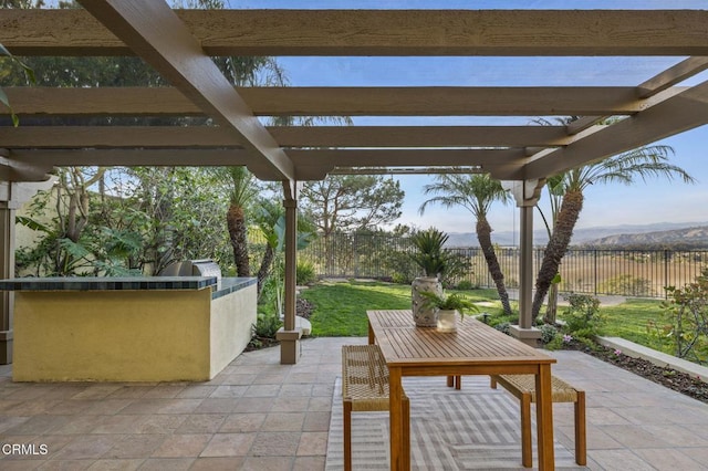 view of patio featuring fence, a mountain view, a pergola, and area for grilling