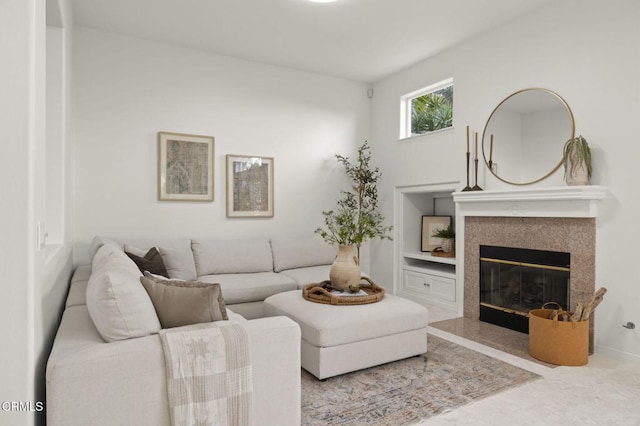 living room featuring built in shelves and a high end fireplace