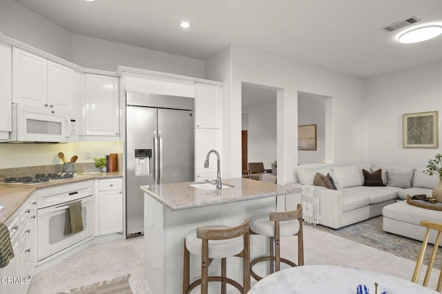 kitchen featuring white cabinets, white appliances, and open floor plan