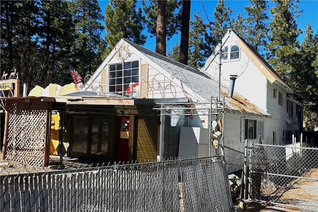 view of front of house featuring roof with shingles and a fenced front yard