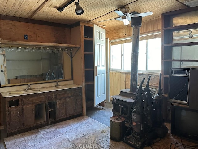 interior space with a ceiling fan, wooden walls, and wooden ceiling