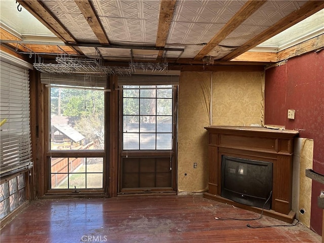 unfurnished living room with a glass covered fireplace and wood finished floors