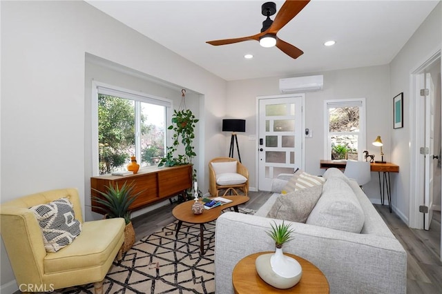 living area featuring baseboards, a wall mounted air conditioner, recessed lighting, wood finished floors, and a ceiling fan