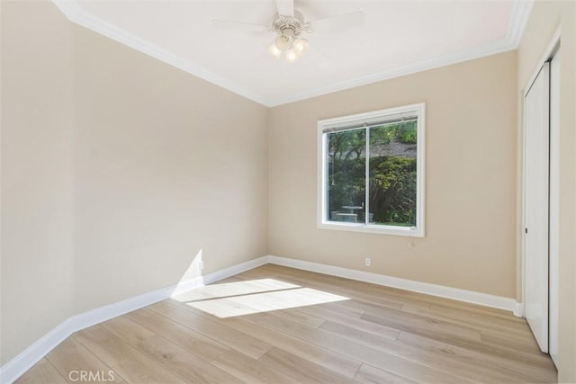 unfurnished bedroom featuring light wood-type flooring, baseboards, ornamental molding, and a closet