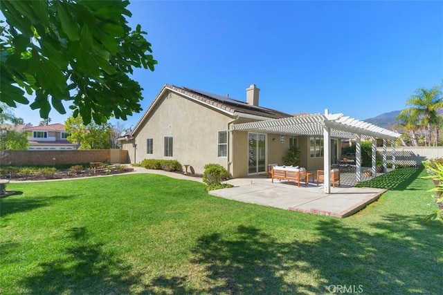 rear view of house featuring a patio, solar panels, fence, and a pergola