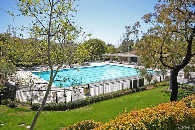 pool featuring fence and a lawn