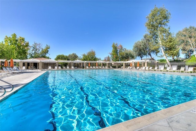 community pool featuring fence and a patio