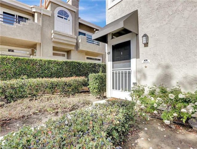 entrance to property featuring stucco siding