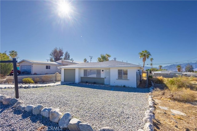 ranch-style house featuring an attached garage and stucco siding