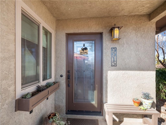 entrance to property featuring stucco siding