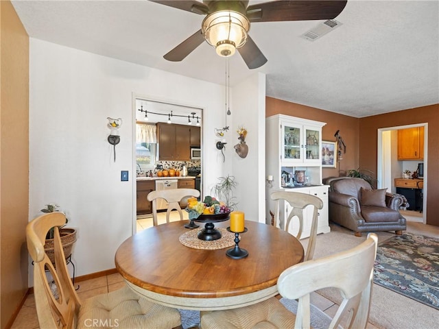 dining area featuring visible vents, ceiling fan, baseboards, and light tile patterned floors