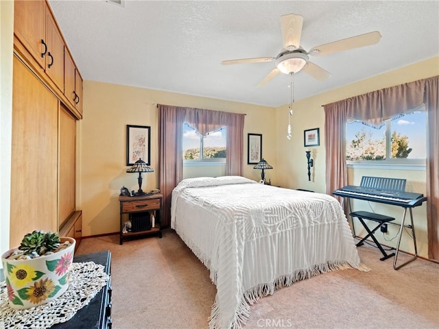 bedroom with light carpet, a closet, a ceiling fan, and baseboards