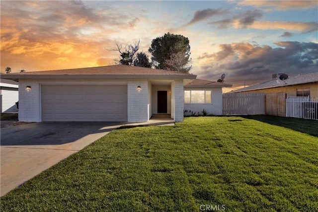 ranch-style house featuring a garage, brick siding, fence, a yard, and driveway