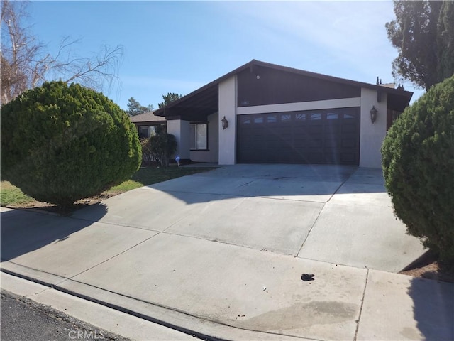 view of front of house featuring a garage, driveway, and stucco siding