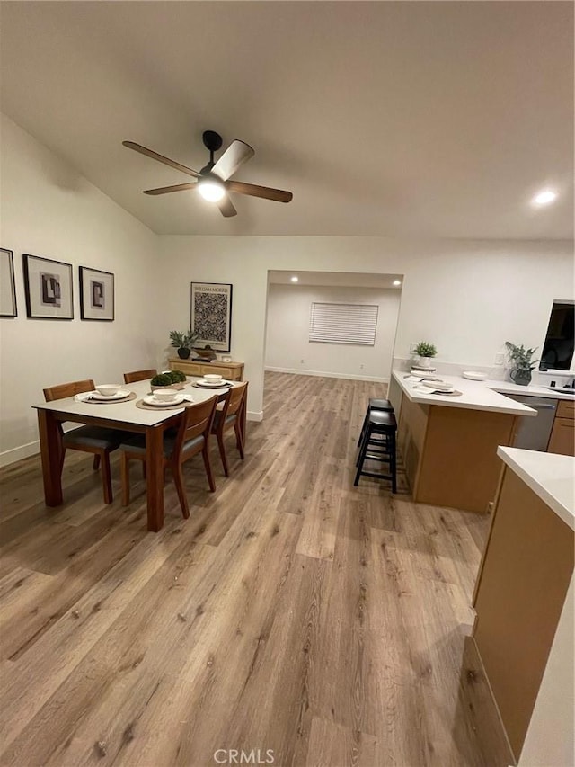 dining room featuring baseboards, a ceiling fan, and light wood-style floors