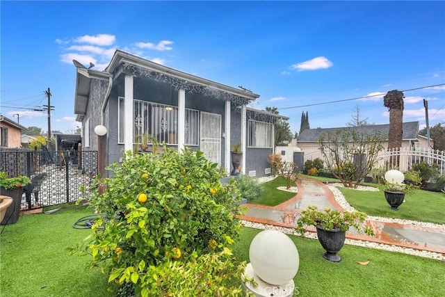 view of side of home featuring a sunroom, fence, a lawn, and stucco siding