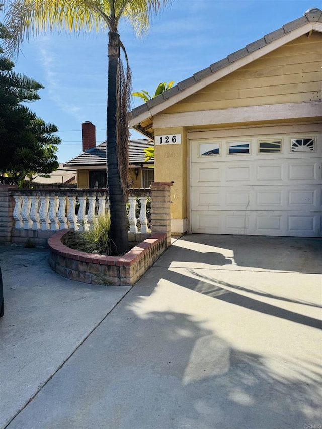 view of front of property with a garage, concrete driveway, and stucco siding