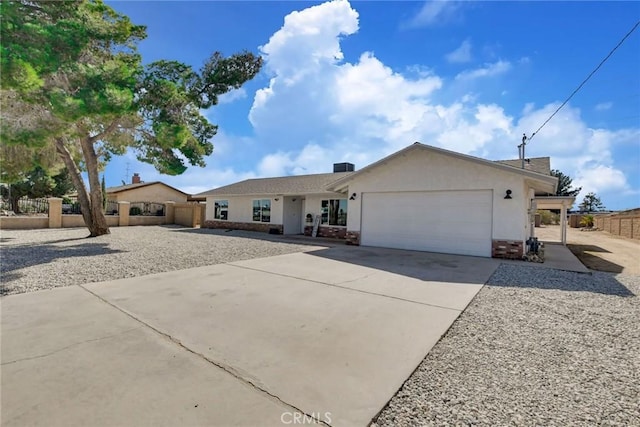 single story home featuring a garage, driveway, fence, and stucco siding