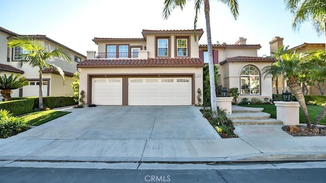 mediterranean / spanish home featuring driveway, an attached garage, a tiled roof, and stucco siding