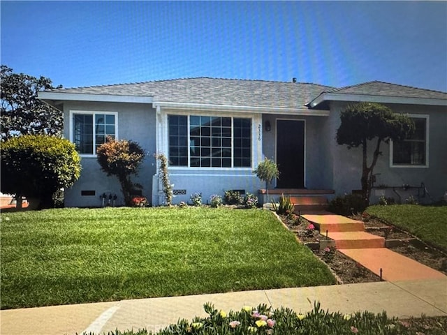 view of front of house with crawl space, roof with shingles, a front lawn, and stucco siding