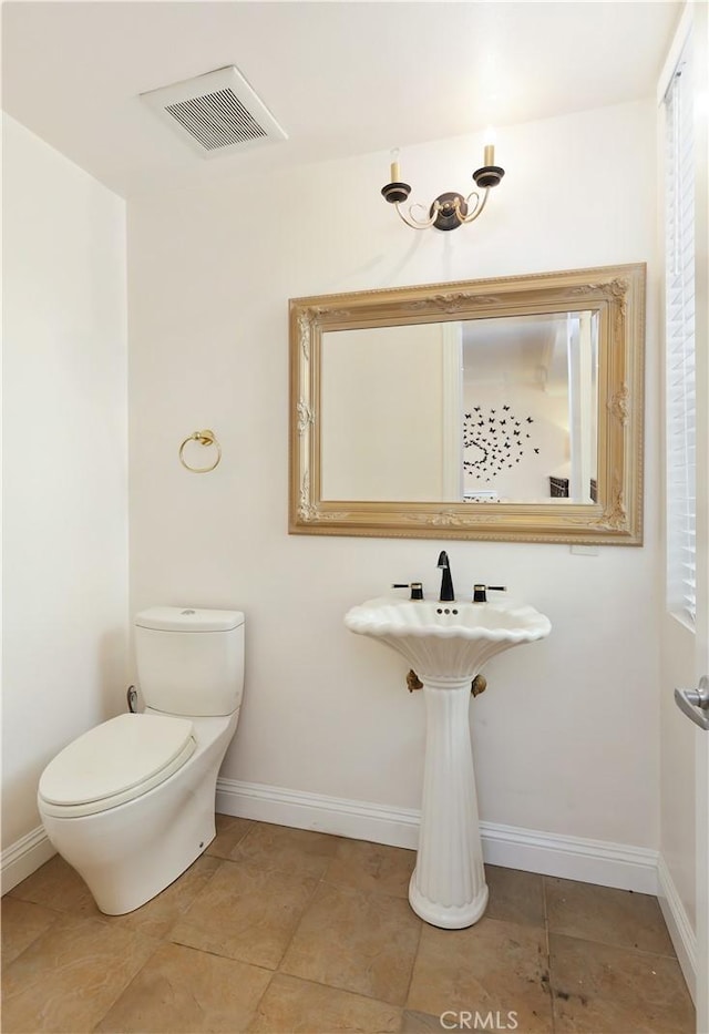 bathroom featuring toilet, baseboards, and visible vents