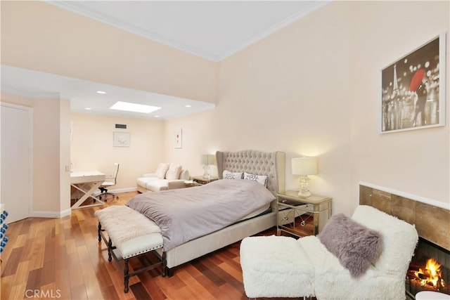 bedroom featuring visible vents, baseboards, wood finished floors, crown molding, and recessed lighting