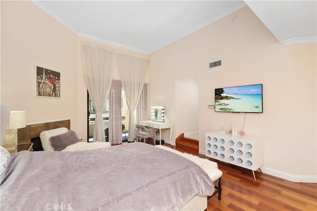 bedroom with baseboards, visible vents, wood finished floors, and ornamental molding