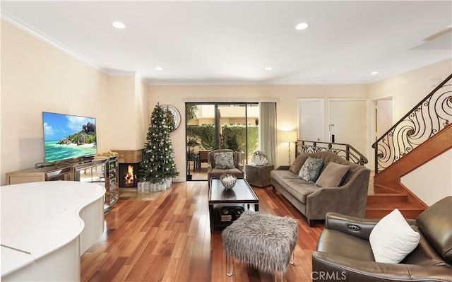 living room featuring recessed lighting, crown molding, stairway, and light wood finished floors