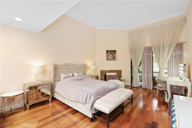 bedroom with crown molding, recessed lighting, wood finished floors, and baseboards