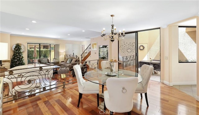 dining room with a chandelier, light wood-type flooring, recessed lighting, and stairs