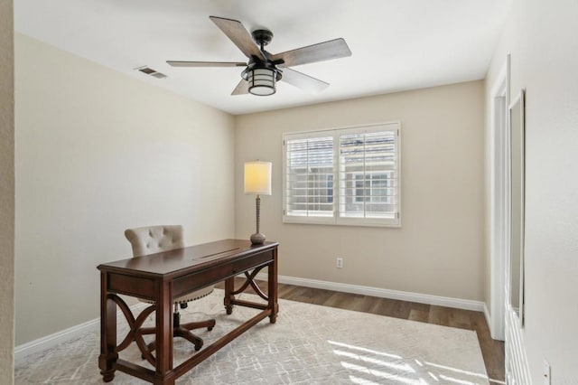 office area with ceiling fan, wood finished floors, visible vents, and baseboards