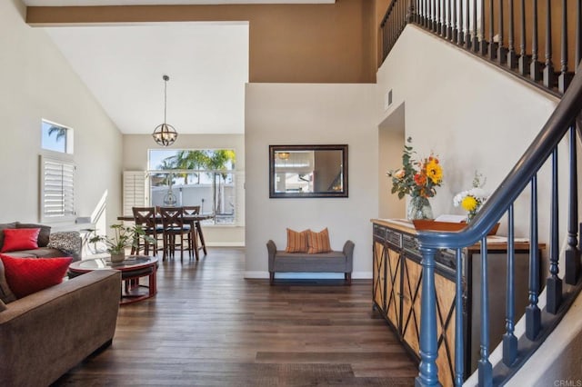 living area with high vaulted ceiling, dark wood-type flooring, visible vents, baseboards, and stairs