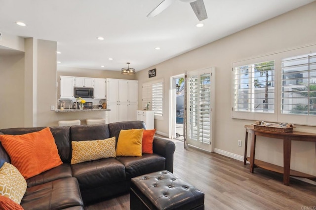 living room with light wood finished floors, ceiling fan, baseboards, and recessed lighting