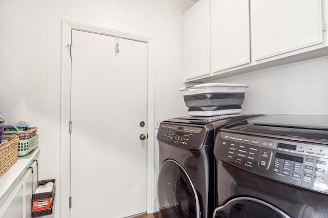 clothes washing area with washing machine and clothes dryer and cabinet space