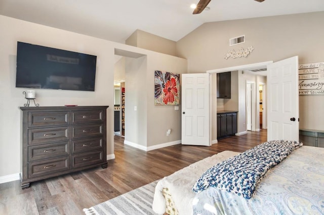 bedroom with dark wood-style floors, baseboards, visible vents, and vaulted ceiling