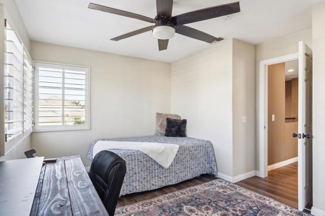 bedroom with ceiling fan, dark wood-style flooring, and baseboards