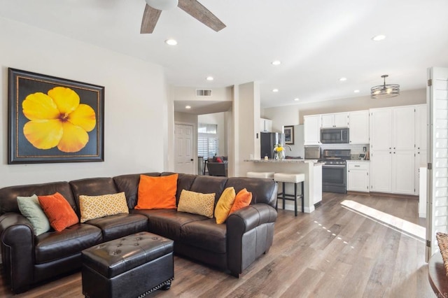 living room with light wood-style floors, recessed lighting, visible vents, and ceiling fan