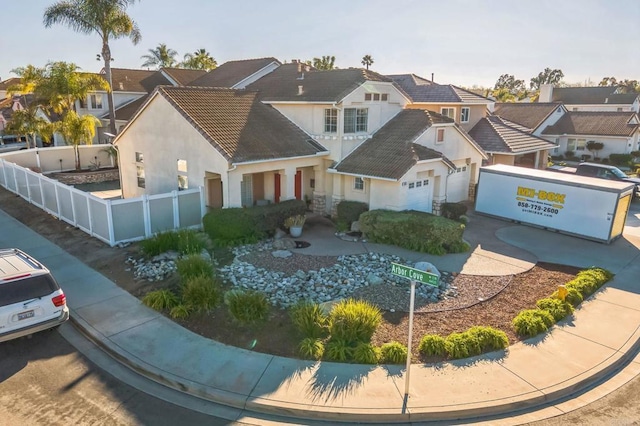 view of front facade with a residential view, fence, and stucco siding