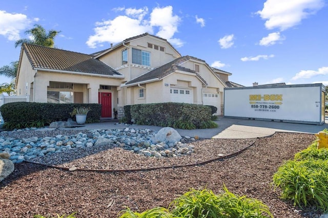 view of front of house featuring an attached garage, a tile roof, and stucco siding