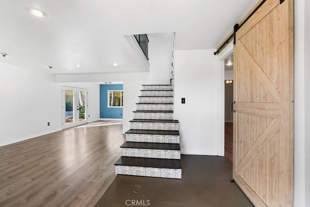 staircase featuring recessed lighting, wood finished floors, baseboards, and a barn door