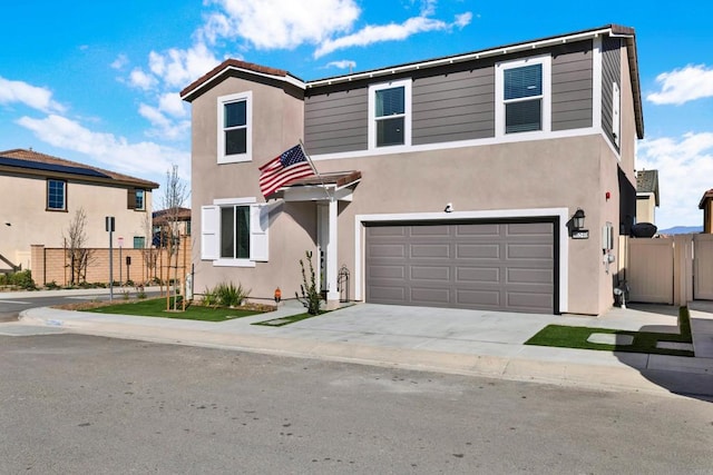 traditional-style house with driveway, a garage, fence, and stucco siding