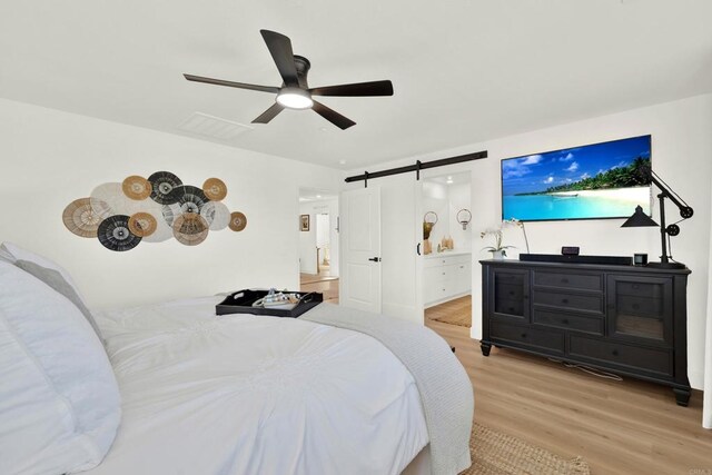 36540 Diego Springs Ave, Murrieta, CA 92563 - bedroom with visible vents, a barn door, light wood-style flooring, and a ceiling fan