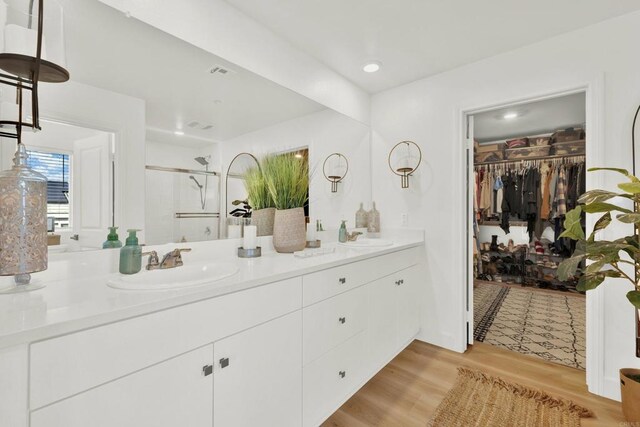 36540 Diego Springs Ave, Murrieta, CA 92563 - bathroom with wood finished floors, a sink, a stall shower, and double vanity