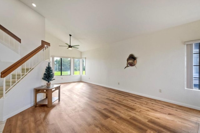 unfurnished living room featuring stairway, baseboards, and wood finished floors