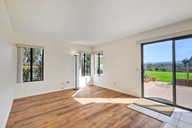 interior space with baseboards and light wood finished floors